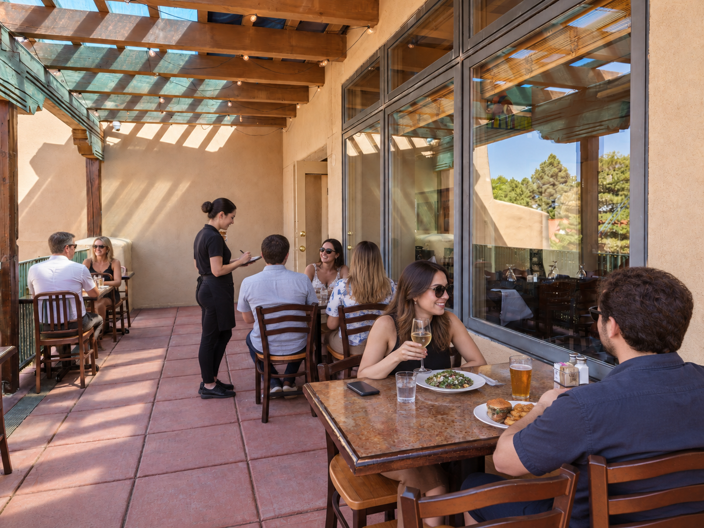 Guests dining on the sunny outdoor patio at AREA 505 in Santa Fe